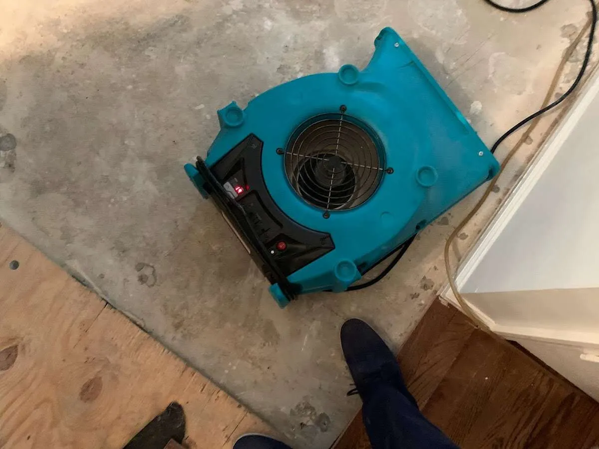 Air mover drying subfloor during Leak Detection & Repair in Oakville